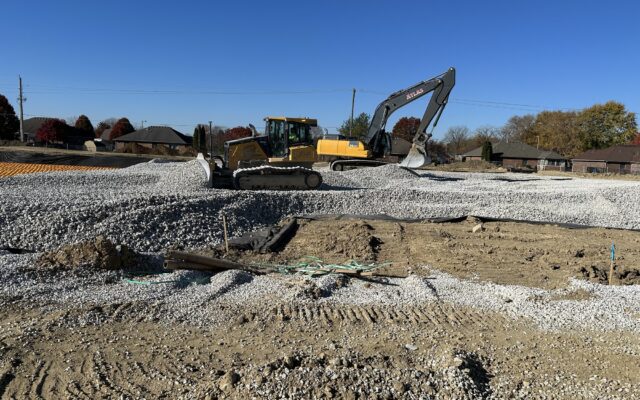Bulldozer and excavator work on a gravel site.