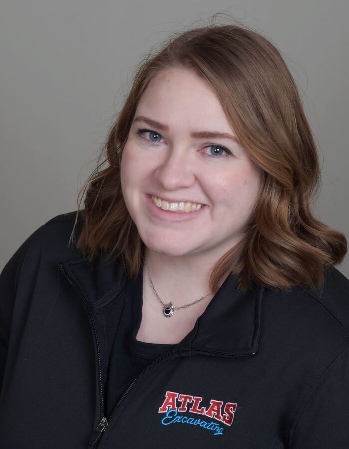 Smiling woman with light brown hair, blue eyes, ATLAS jacket.