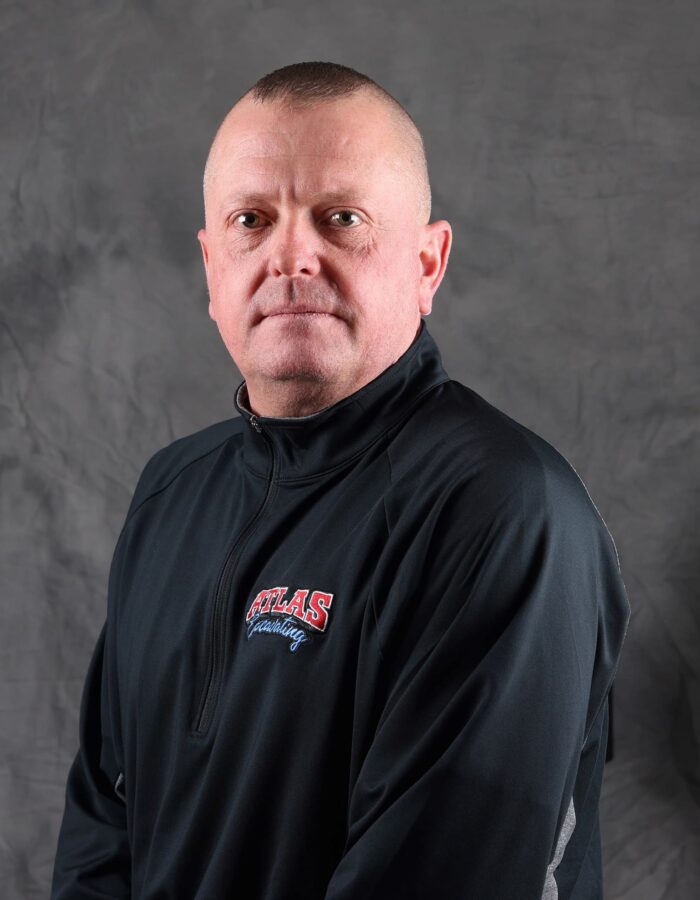 Man in ATLAS jacket poses for portrait.