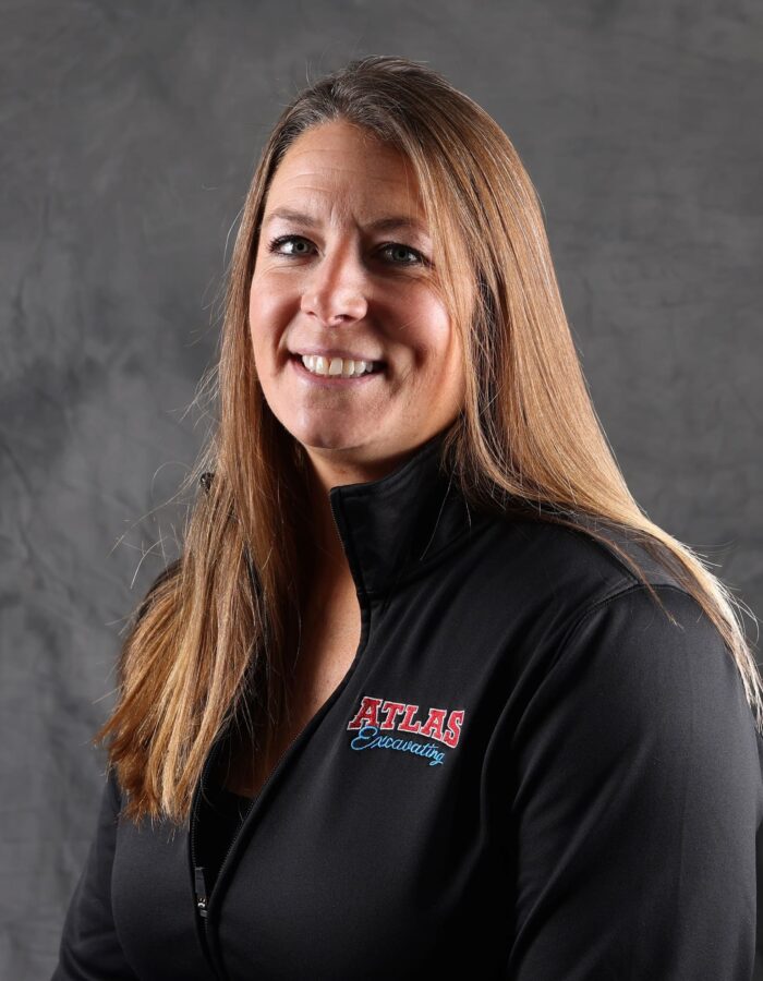 Woman in black Atlas jacket against gray background.