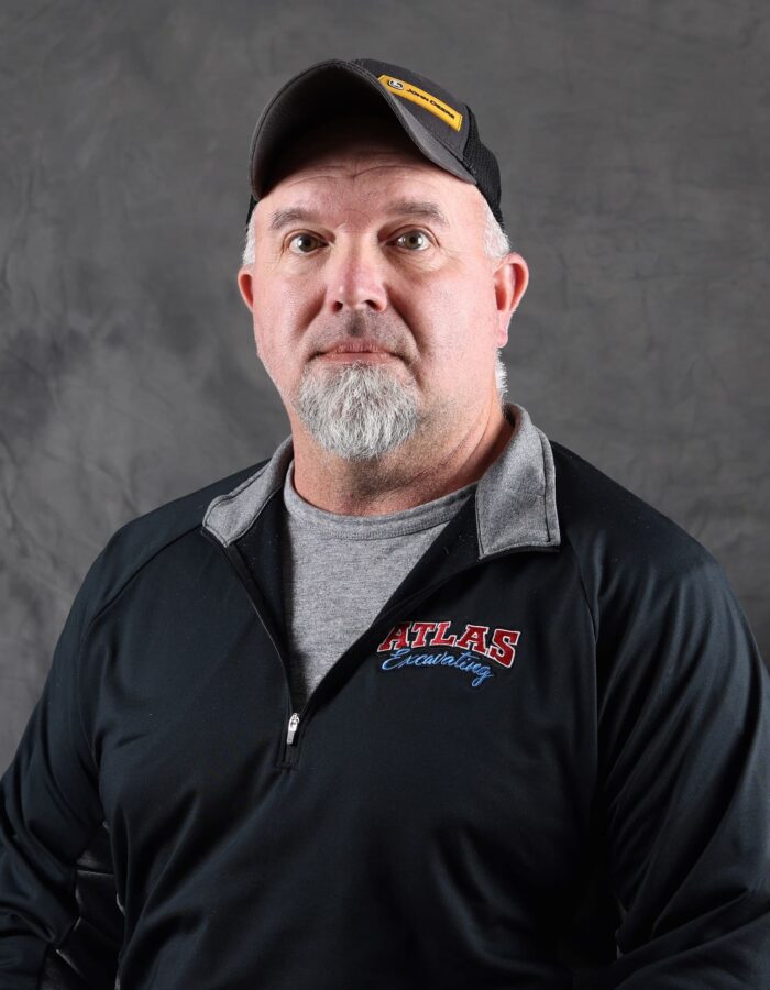 Man with goatee in black ATLAS pullover and cap.