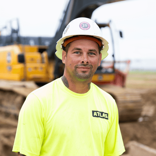 Worker in neon yellow shirt and hard hat at worksite.
