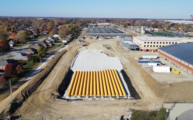 Aerial view: yellow pipes on white at a construction site.