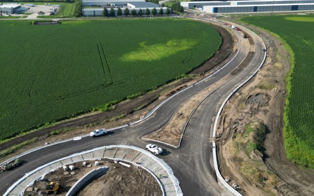 Aerial view of new roundabout, roadway, and farmland with equipment.