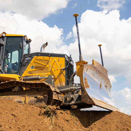 Yellow bulldozer pushes dirt on a construction site.