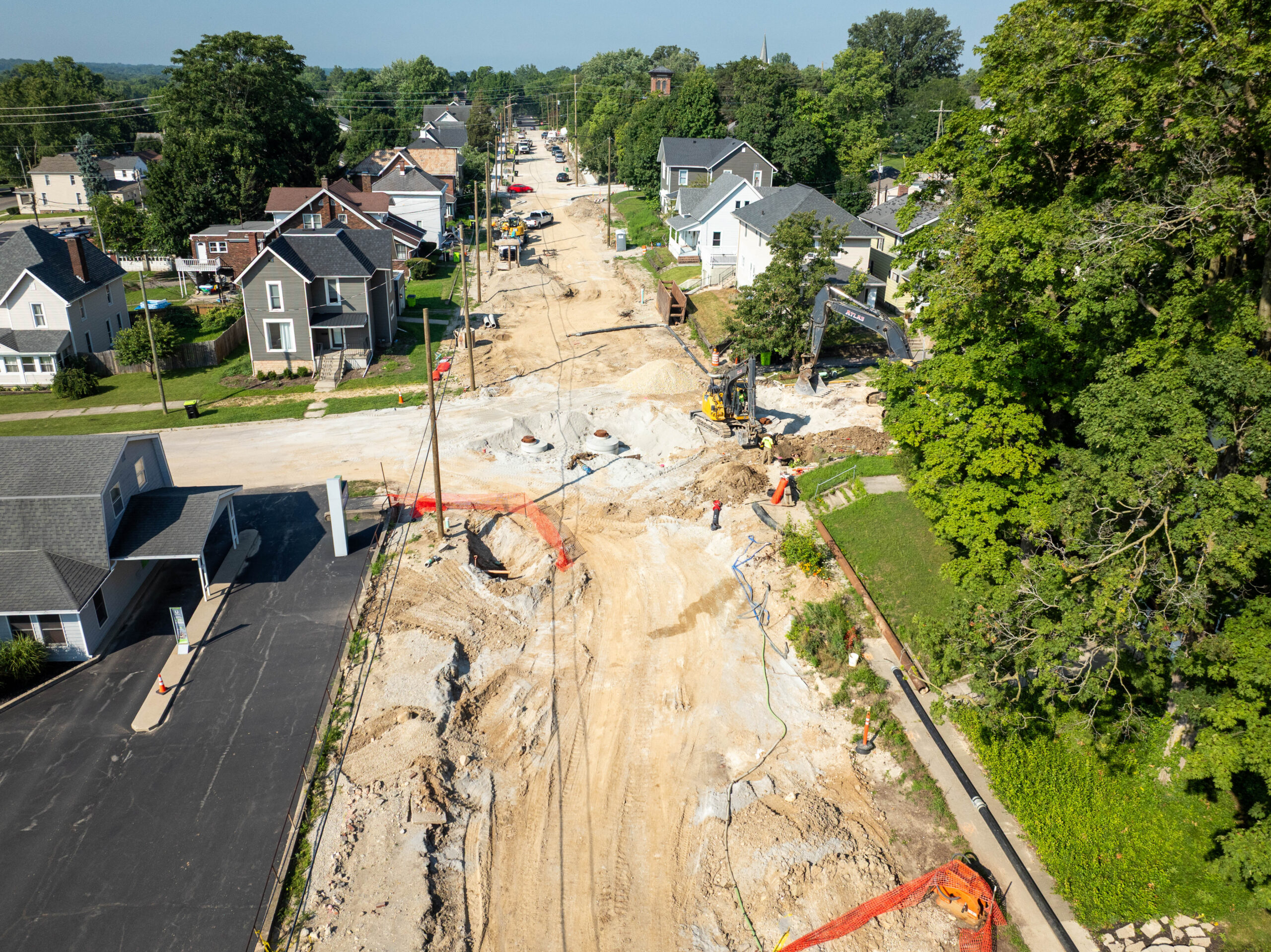 Aerial view of a residential street with heavy construction equipment.