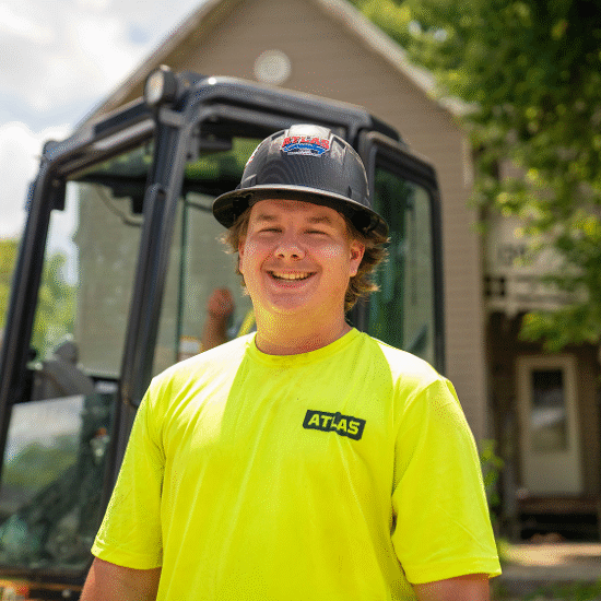 Smiling construction worker in neon ATLAS shirt and hard hat.
