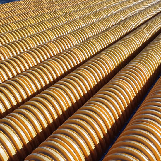 Yellow ridged pipes stacked outdoors in a geometric pattern.