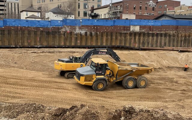 Two yellow construction vehicles parked on a dirt site.