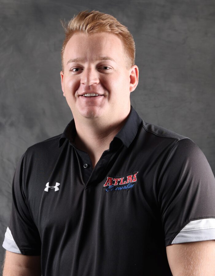Smiling man with short light hair in black Atlas polo.