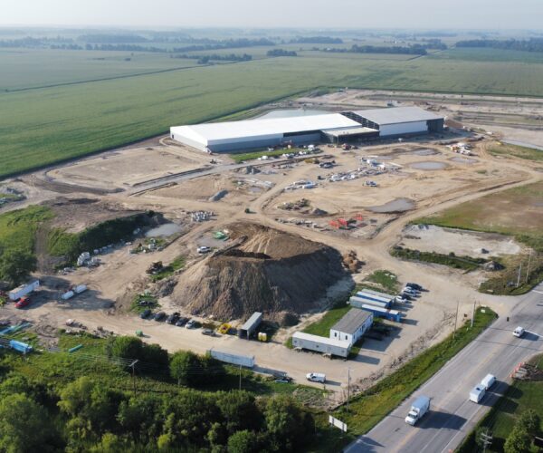 Aerial view of two white-roofed buildings at construction site.